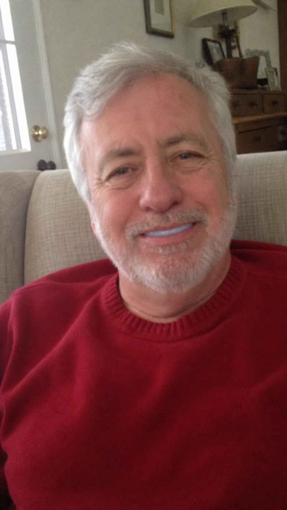 Older man in red sweater smiling